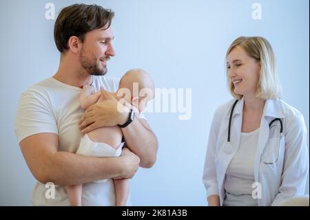 Der junge Vater erhält eine ärztliche Beratung durch einen erfahrenen Kinderarzt Stockfoto