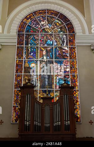 Eine vertikale Aufnahme eines Buntglasfensters hinter der Orgel in der Metropolitan Cathedral in Porto alér, Rio Grande do Sul, Brasilien Stockfoto