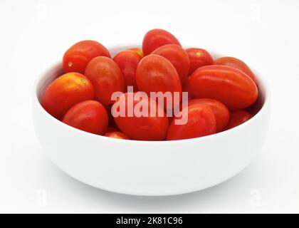 Rote Kirschtomaten in einer Schüssel isoliert auf weißem Hintergrund. Stockfoto