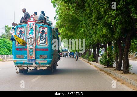 Ein kleiner blauer Bus und Fahrräder auf Korangi Straßen in Karachi, Pakistan Stockfoto