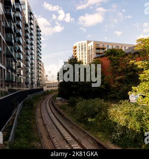 Blick von der Kew Bridge, über die Themse, Kew, West London, Großbritannien, mit Eisenbahnlinie und Wohnblocks Stockfoto