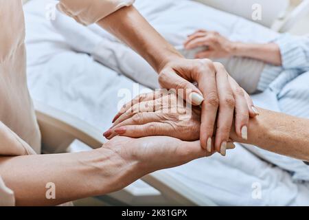 Relativer, zitternder Arm einer älteren Frau mit Parkinson-Krankheit, die im Krankenhausbett auf der medizinischen Station liegt. Diagnose und Behandlung von Parkinson Stockfoto