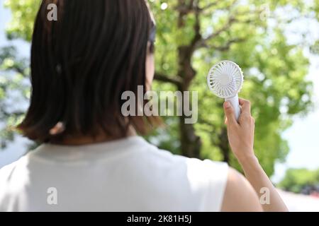Japanische Frau mit einem tragbaren Ventilator Stockfoto
