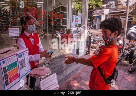 Während eines Ausbruchs von COVID - 19, bekommt ein Teenager-Junge mit gemischter Rasse (Kambodschanisch - Amerikaner), Phnom Penh, Kambodscha, seine Hände desinfiziert. © Kraig Lieb Stockfoto