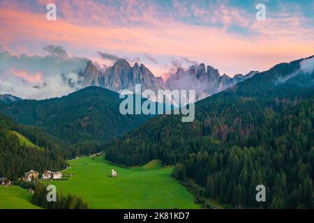 Landschaftlich reizvolle Landschaft vom Tal Santa Maddalena mit den alten Gipfeln der Dolomiten mit magischem rosa Sonnenuntergang. Stockfoto