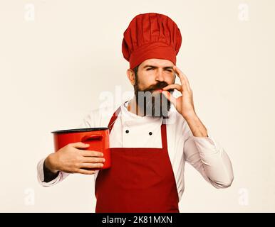 Kochen Sie mit zufriedenen Gesicht in burgunderroten Uniform hat Auflauf Stockfoto