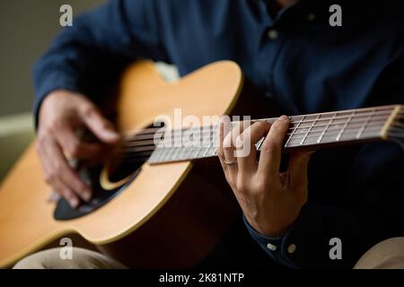 Japanischer Mann spielt akustische Gitarre Stockfoto