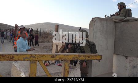 NABLUS, WESTJORDANLAND - 19. OKTOBER: Palästinensische Männer streiten sich mit israelischen Soldaten, während sie darauf warten, am 19. Oktober 2022 den Militärkontrollpunkt Beit Furik zu überqueren, der sich am östlichen Eingang von Nablus, Westjordanland, befindet. Die israelischen Streitkräfte haben eine anhaltende Blockade des Gebiets um Nablus verhängt, inmitten erhöhter Spannungen im Westjordanland, die die Bewegung von etwa 420.000 Palästinensern einschränkten. Kredit: Eddie Gerald/Alamy Live Nachrichten Stockfoto