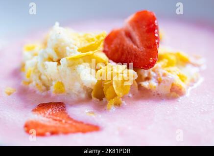 Obstsuppe mit Erdbeer-Quark und Maisflocken Stockfoto