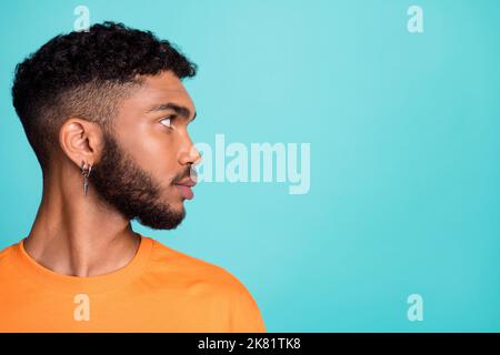 Nahaufnahme Profil Seite Foto von ernsthaften zuversichtlich Mann tragen orange Kleidung zufrieden Frisur suchen leeren Raum isoliert cyan Farbe Hintergrund Stockfoto