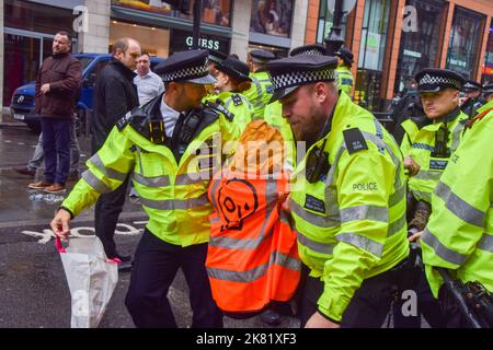 London, Großbritannien. 20.. Oktober 2022. Die Polizei verhaftete einen Protestierenden. Just Stop Oil-Aktivisten klebten ihre Hände und befestigten sich an Metallrohren an der Brompton Road vor Harrods und sprühten orangene Farbe auf die Fenster des berühmten Kaufhauses in Knightsbridge, während sie ihre Proteste fortsetzen und die Regierung fordern, keine neuen Lizenzen für fossile Brennstoffe mehr auszugeben. Kredit: Vuk Valcic/Alamy Live Nachrichten Stockfoto