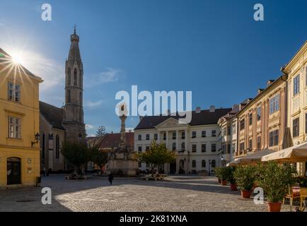 Sopron, Ungarn - 7. Oktober 2022: Blick auf den Hauptplatz und die Kirche in der historischen Altstadt von Sopron mit einem Sonneneinbruch Stockfoto