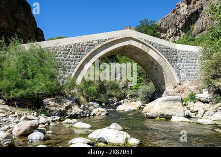 Die historische Hanım-Brücke, die sich am Pülümür-Bach innerhalb der Grenzen des Tunceli-Bezirks Pülümür befindet und im 19.. Jahrhundert erbaut wurde Stockfoto