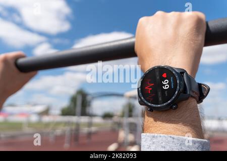 Nahaufnahme des Smart Watch Health Tracker mit der auf dem Bildschirm angezeigten Herzfrequenz. Modernes, elegantes und innovatives tragbares Gerät. Sportler überprüft sein Hörvermögen Stockfoto