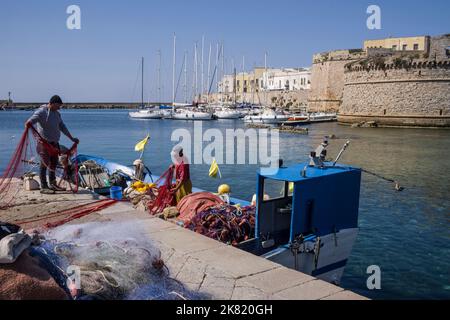 Italien, Region Apulien: Gallipoli; Fischer im Fischereihafen mit der Burg im Hintergrund Stockfoto