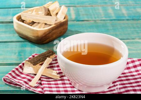 Quassia Amara - Getränkestängel von Quassia Heilpflanze; auf Holzhintergrund Stockfoto