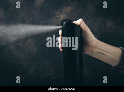 Konzeptuelles Bild der Chromierung. Prozess des Hochhaltens mit Haushaltschemikalien zum Einatmen. Kinderhand mit Haarspray-Flasche und Spray-Aerosol. Stockfoto