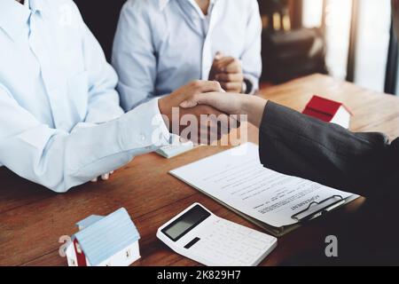 Immobilienmakler schütteln die Hände mit Kunden nach der Unterzeichnung von Dokumenten Stockfoto