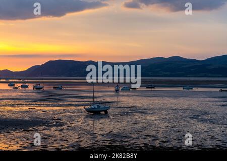 Farbenfroher Sonnenaufgang auf der Menai Strait und den Bergen von Snowdonia bei Ebbe Stockfoto
