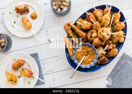 Eine Platte mit frittierten Vorspeisen, serviert mit heißem Senf zum Eintauchen. Stockfoto