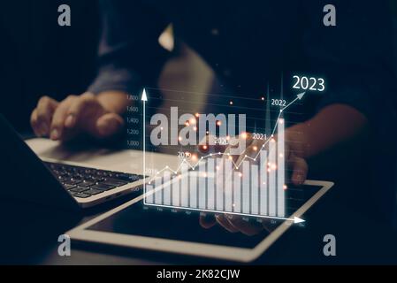 Finanzdiagramme und Graphenanalyse-Marketing, das den wachsenden Umsatz im Jahr 2023 über dem digitalen Bildschirmtablett zeigt, Geschäft über Wachstumsstrategie Stockfoto