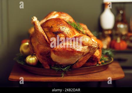 Gebutterter Thanksgiving-truthahn, der auf einem Teller mit grünem Gemüse auf einem Holztisch mit verschwommenem Hintergrund liegt Stockfoto