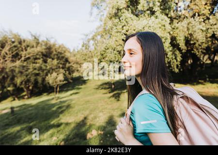 Seitenansicht junges Studentenmädchen mit rosa Rucksack Blick auf den Horizont vom Hügel. Selbstvertrauen. Stockfoto