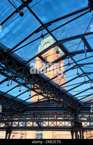 Die Stahlkonstruktion des Glasdachs und der Uhrenturm in der alten Brauerei in Poznan Stockfoto