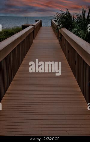Fußgänger-Promenade, die sich bei Sonnenuntergang bis zum Amelia Beach, Florida erstreckt. Stockfoto