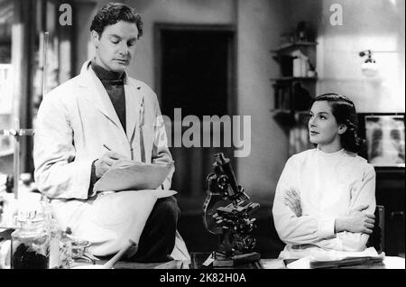 Robert Donat & Rosalind Russell Film: Die Zitadelle (1935) Charaktere: Dr. Andrew Manson & Christine Manson 01 May 1938 **WARNUNG** Dieses Foto ist nur für den redaktionellen Gebrauch bestimmt und unterliegt dem Copyright der Film Company und/oder des Fotografen, der von der Film- oder Produktionsfirma beauftragt wurde und kann nur durch Publikationen im Zusammenhang mit der Bewerbung des oben genannten reproduziert werden Film. Eine obligatorische Gutschrift an die Filmgesellschaft ist erforderlich. Der Fotograf sollte auch bei Bekanntwerden des Fotos gutgeschrieben werden. Ohne schriftliche Genehmigung der Film Company kann keine kommerzielle Nutzung gewährt werden. Stockfoto