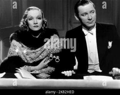 Marlene Dietrich, Herbert Marshall Film: Angel (USA 1937) Charaktere: Maria 'Angel' Barker, aka Mrs. Brown,Sir Frederick Barker Regie: Ernst Lubitsch 22. Oktober 1937 **WARNUNG** Dieses Foto ist nur für redaktionelle Zwecke bestimmt und unterliegt dem Copyright von PARAMOUNT und/oder des Fotografen, der von der Film- oder Produktionsfirma beauftragt wurde und darf nur von Publikationen im Zusammenhang mit der Bewerbung des oben genannten Films reproduziert werden. Eine obligatorische Gutschrift an PARAMOUNT ist erforderlich. Der Fotograf sollte auch bei Bekanntwerden des Fotos gutgeschrieben werden. Ohne schriftliche Genehmigung der Film Compan kann keine kommerzielle Nutzung gewährt werden Stockfoto