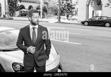 Schöner reifer Mann in geschäftsähnlichen Anzug stehen von Luxus-Auto im Freien, kopieren Raum, Erfolg. Stockfoto