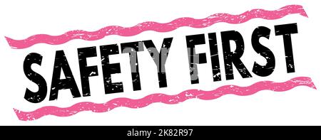 SICHERHEIT ERSTER Text auf rosa-schwarzen Linien Stempelzeichen geschrieben. Stockfoto