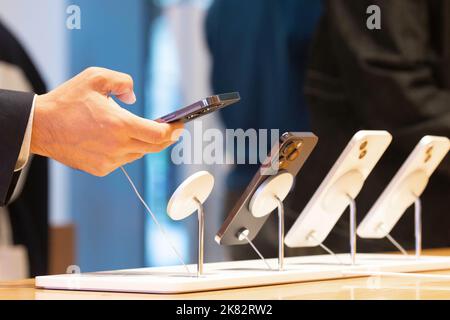 Der Kunde interagiert mit dem iPhone 14 Pro Max im Apple Store in Marunouchi, Tokio. Stockfoto