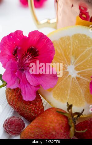 Textur aus Zitronenscheibe und frischen Erdbeeren, Zitrusfrüchten im Studio mit einer natürlichen Blume, Schönheit und Stil Stockfoto