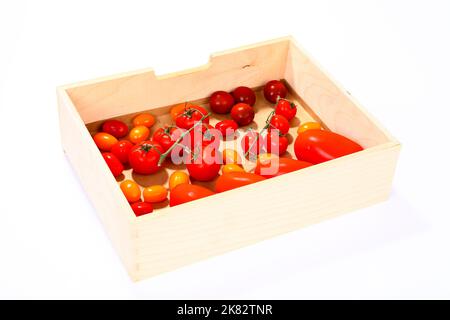 Frische reife gemischte Tomaten in einer Holzkiste Stockfoto
