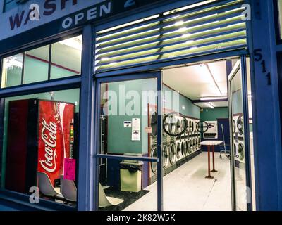 AMERICANA Waschsalon, Münzwaschmaschine, Waschmaschine, Tür offen und Coca-Cola-Maschine bei Nacht Pacific Grove, Kalifornien, USA Lifestyle Stockfoto