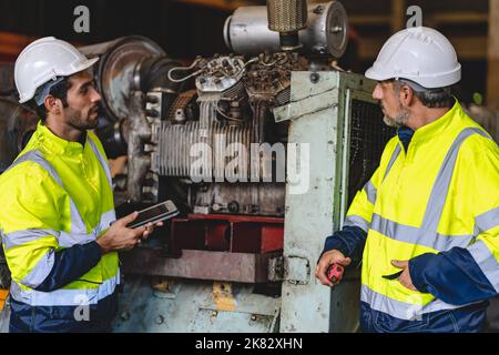 Professioneller Techniker Ingenieur arbeitet, um das Sicherheitssystem der schweren Industrie Produktionsmaschine in der Bauanlage zu überprüfen und eine Fabrik eq Stockfoto