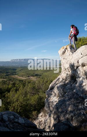 Frau, die den Panoramablick auf das Dorf Trets und die Montagne Sainte-Victoire im Hintergrund bei Sonnenuntergang, Südfrankreich, bewundert Stockfoto