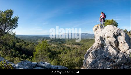 Frau, die den Panoramablick auf das Dorf Trets und die Montagne Sainte-Victoire im Hintergrund bei Sonnenuntergang, Südfrankreich, bewundert Stockfoto