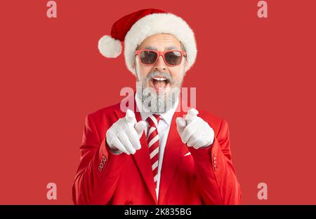 Fröhlicher Mann in Santa hat zeigt seine Finger auf Sie und fragt, ob Sie bereit für Silvester-Party sind Stockfoto