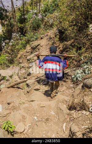 KOSOYE, ÄTHIOPIEN - 14. MÄRZ 2019: Bewaffnete Pfadfinder-Eskorte wandern in den Bergen in der Nähe des Dorfes Kosoye, Äthiopien Stockfoto