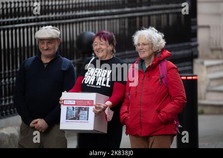 Westminster, London, Großbritannien. 19.. Oktober 2022. Die Rentnerin Diane Skidmore (schwarzes T-Shirt) und Ruth London reichen die Petition „Energie für alle“ ein, die von über 650.000 Menschen in der Downing Street Nr. 10 unterzeichnet wurde. In der Petition wird die Ministerin Liz Truss aufgerufen, Maßnahmen zu ergreifen, um den Menschen zu helfen, die unter Treibstoffarmut leiden, indem sie jedem eine freie Menge an Energie zur Verfügung stellt. Um für dieses neue Preissystem zu zahlen, fordert The Energy for All, eine Petition, die über 650.000 Personen unterzeichnet hat, die Regierung auf, eine Windfallsteuer auf die Gewinne von Öl- und Gasproduzenten, Händlern und Lieferanten einzuführen und die Subventionierung fossiler Brennstoffe mit mi einzustellen Stockfoto