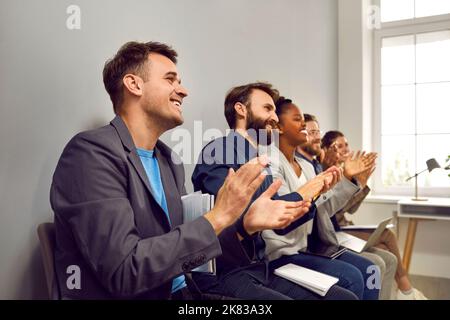 Glückliches Publikum, das dem Redner nach einer erfolgreichen Präsentation in einem Geschäftsmeeting applaudiert Stockfoto
