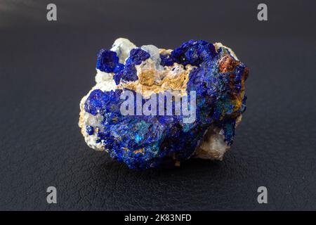 Makroblauer Azurit-Cluster auf weißem Matrix isolierter Kristall auf schwarzem Hintergrund Stockfoto