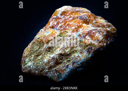 Roher oranger Calcit-Stein-Makro isoliert auf schwarzem Hintergrund Stockfoto