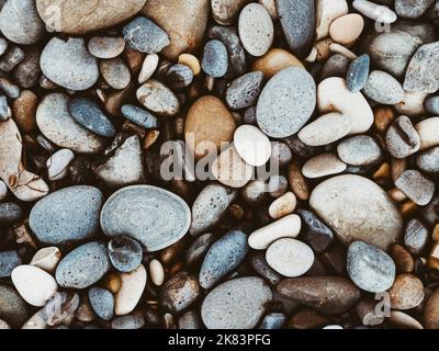 Gruppe von weißen, braunen, grauen und schwarzen Kieselsteinen. Natur strukturierter Hintergrund. Draufsicht Stockfoto