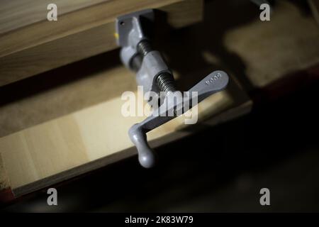 Befestigungselemente für Platine. Befestigungsdetails. Holzwerkstatt. Kleiner Halter mit Hebel. Stockfoto