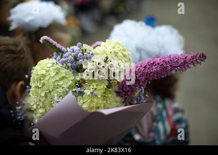 Festlicher Blumenstrauß. Blumen im Kind. Der Unterricht bringt dem Lehrer Blumen. Details zum Urlaub. Stockfoto