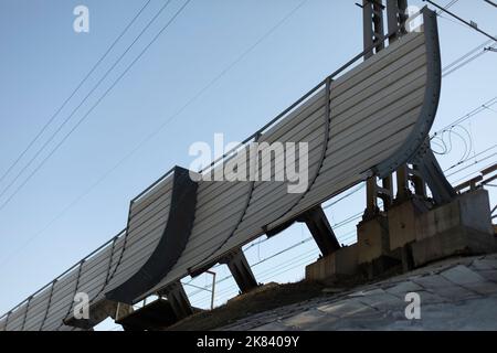 Zaun durch die Eisenbahn. Straßenzaun. Schallisolierte Wand an der Eisenbahn. Stockfoto